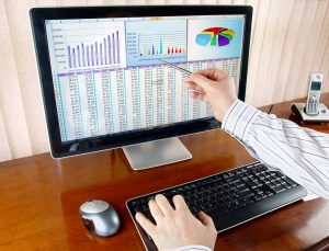 איש מצביע על מסך מחשב עם גרפים ומספרים
