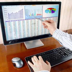 איש מצביע על מסך מחשב עם גרפים ומספרים